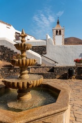 Water fountain next to the white church of Betancuria, west coast of the island of Fuerteventura, Canary Islands. Spain