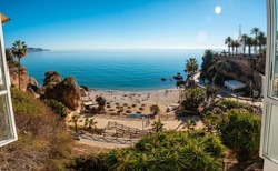 Panoramic of Calahonda beach in the town of Nerja with people sunbathing in spring, Andalusia. Spain. Costa del sol in the mediterranean sea