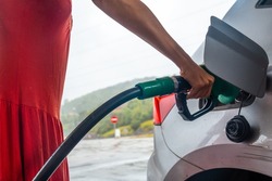 Woman refueling gasoline at the gas station in the fuel crisis with the high prices