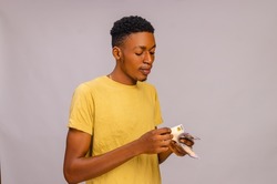 handsome african boy isolated over white background counting his salary