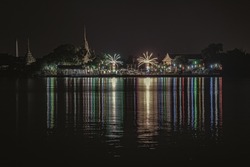 Riverside thai local temple is decorated with different color fireworks in the full moon festval. Space for text, Selective Focus.