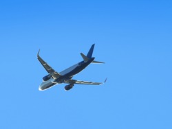 Airplane flying high in the blue sky.
