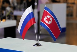 Table flags of the Russian Federation and North Korea together at some event or fair. Flags of the two countries as a symbol of cooperation between states. Joint business of North Korea and Russia