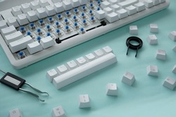 Concept of cleaning disassembled mechanical keyboard game with switch puller and keycaps puller isolated on a white background
