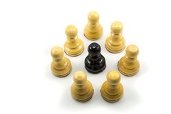 The concept of bullying and racism, world social problems, a group of white chess pawns make a circle in the middle there is a black chess pawn as a victim.