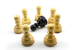 The concept of bullying and racism, world social problems, a group of white chess pawns make a circle in the middle there is a black chess pawn as a victim.