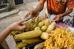 Transaction of buying and selling corn and boiled soybeans using cash.