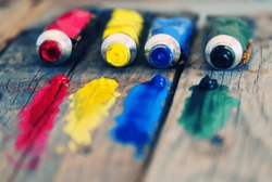 Photo of  4 paint tubes: red, yellow, blue and green