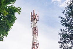 Cell tower against a blue sky with clouds