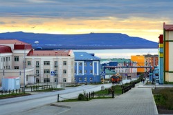 Morning cityscape. Sunrise over hills and colorful buildings. Anadyr is the administrative center of the Chukotka Autonomous Region of Russia. Away above the street is the text in Russian 