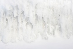 Ice texture. Natural background with large icicles. Cold winter weather. Icy coastal cliffs. Severe frost. The nature of the Arctic. Polar region, Extreme North. Great for background and design.