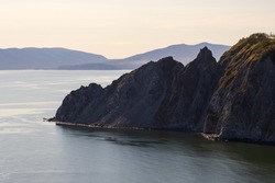 View of the rocky cape and mountains. Beautiful landscape. Natural landmark of the Magadan region. Journey to the Far East of Russia. Cape Nyuklya, coast of the Sea of Okhotsk, Magadan region, Russia.