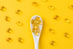 Close up of  oil filled capsules on spoon suitable for: fish oil, omega 3, omega 6, omega 9,  vitamin A, vitamin D, vitamin D3, vitamin E 