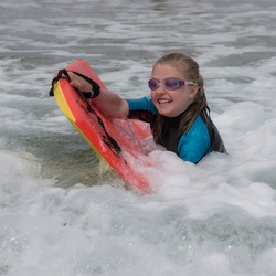 A girl rides on her boogie boarder