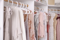 Beautiful female wardrobe. A lot of party dresses hanging on hangers in closet. Vintage clothing rental concept. Women's space. Large selection of various clothes. Small boutique showroom fashion shop
