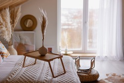 beautiful boho interior details. Pampas grass in a vase. Hygge mood. Cozy morning in the fall. Bedroom in a country house. The bed is covered with a blanket. coffee table. Relax environment
