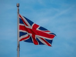 Union Jack, the National Flag of the United Kingdom on a flag pole, flying in the breeze, red, white and blue, Great Britain