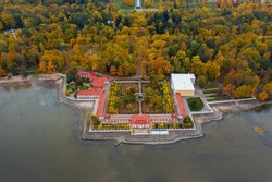 Aerial view of the lower park in Peterhof, the Monplaisir Palace, the promenade along the Gulf of Finland, a garden of autumn trees and a fountain in the center