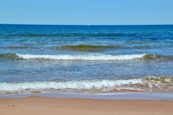 Ocean horizon and series of waves approaching beach at PEI National Park during Summer