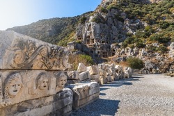Historical Stone faces bas relief and ancient theater at Myra ancient city. Rock-cut tombs Ruins in Lycia region, Demre, Antalya, Turkey.  