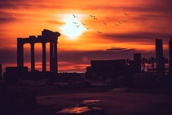Silhouette of Apollon Temple in Side antique city, temple of Apollon ancient ruins at sunset. Greek ancient historical antique Side Antalya Turkey.