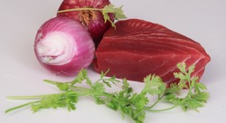 tuna isolated. Piece Fish tuna Red. Onions And coriander Green With slice Tuna On background White