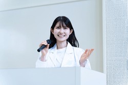 Japanese woman holding a microphone and talking
