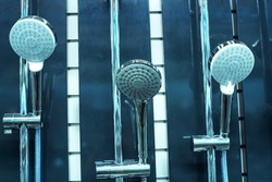 Shower heads. An assortment of plastic and chromed metal products on a counter in a plumbing retail chain. Close-up