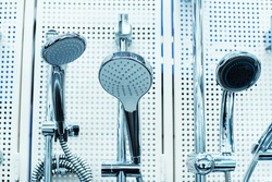 Shower heads of various types on the counter in the store. Selection of plumbing in a specialized wholesale and retail network. Close-up