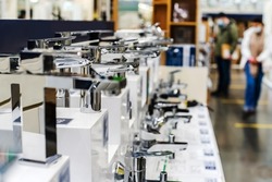 Water taps of different types and shapes on the counter in the store. Retail trade in sanitary ware. Foreground. Selective focus
