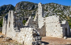 Ruins of stone walls of the ancient city Olympos located on the Mediterranean coast of Lycian way. Cirali, Turkey