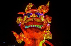 Traditional lamps from the Chinese Lantern Festival in honor of the New Year. Sculpture depicting a red dragon with street lighting