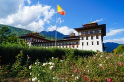 Bhutan, Thimphu, traditional  administration building with rose garden and parc. Bhutanese flag