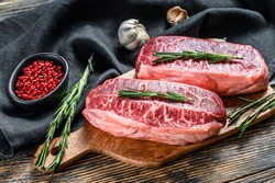 Raw marbled beef steak, top blade meat steak. Black background. Top view