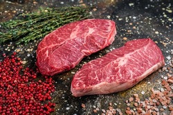 Raw Shoulder Top Blade cuts, beef meat steaks. Brown background. Top View
