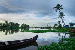 Wooden fishing  boat on river - Backwaters photography, typical landscape with palm trees and old hut, Kerala Backwaters, Kerala backwaters photography during day time Kadamakkudy Kerala