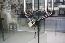 The glass door was locked with padlocks and chains.Locked glass door with chain