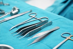 Surgical instruments, surgery, placed on a sterile green cloth, soft focus                               
