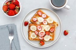 Square belgian waffles with strawberries berries,bananas,condensed milk,honey on plate, cup of coffee espresso. Tasty breakfast, sweet dessert food.selective focus, close up top view flat lay.