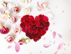   Red Heart  symbol on  pink roses flower petal on white  festive floral background 