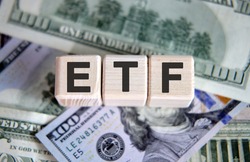 ETF financial business concept. Wooden cubes and paper dollar bills as a background