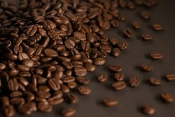 Roasted coffee beans background. Many aromatic coffee beans on a dark background. Selective focus. The concept of an advertising banner for a coffee shop or chain of commodity production.