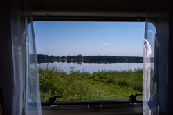 View from a window of camper to beautiful lake lanscape
