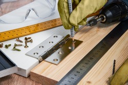 Installation of furniture hinges in the chipboard, tools and accessories needed to perform the work. Small carpentry work at home, the concept of a home master, self-repair of the house