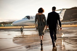 Well-dressed couple walking towards a private jet