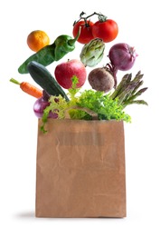 Vegetables flying in recycled paper bag, isolated from white background