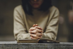 Christian life crisis prayer to god. Woman holding hands pray for god blessing to wishing have a better life on a wooden table. Woman hands praying to god with the bible. believe in goodness.