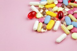 Colorful capsules on a pink background