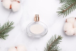 Perfume bottle with fir tree branch, cotton flowers. New year, Christmas perfume gift. Winter holiday celebration perfume composition. Idea for gift with love.