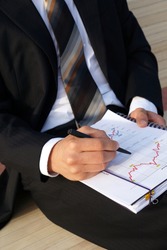 Businessman evaluates company data and checks charts and values